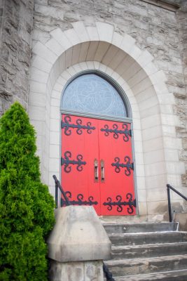 Red doors in arched entrance to stone building